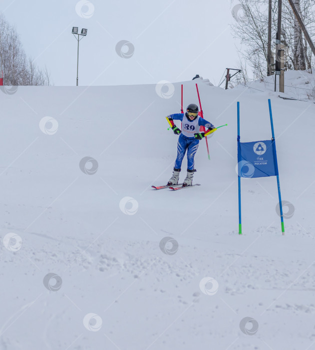 Скачать Россия, Красноярск 25 февраля 2025г. Мальчик лыжник, спускается на лыжах по снежному склону. фотосток Ozero