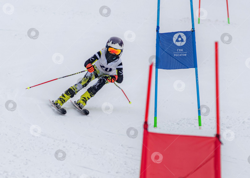 Скачать Россия, Красноярск 25 февраля 2025г. Мальчик лыжник, спускается на лыжах по снежному склону. фотосток Ozero