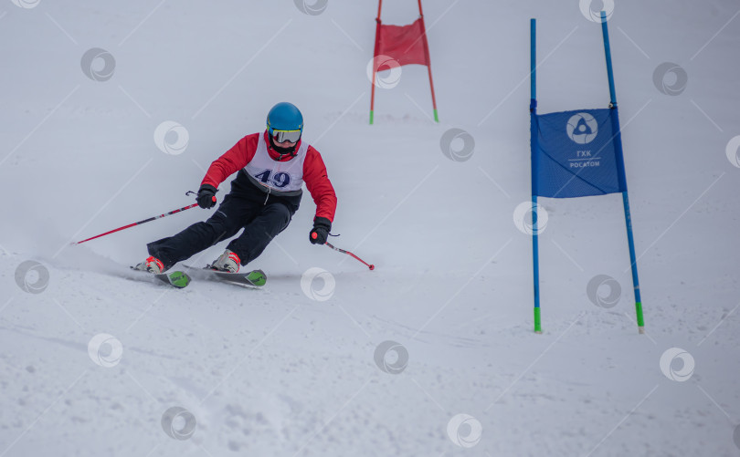 Скачать Россия, Красноярск 25 февраля 2025г. Мальчик лыжник, спускается на лыжах по снежному склону. фотосток Ozero