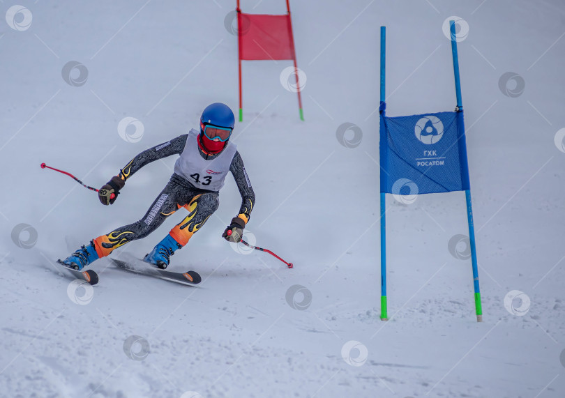 Скачать Россия, Красноярск 25 февраля 2025г. Мальчик лыжник, спускается на лыжах по снежному склону. фотосток Ozero