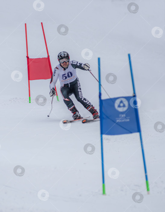 Скачать Россия, Красноярск 25 февраля 2025г. Мужчина лыжник, спускается на лыжах по снежному склону. фотосток Ozero