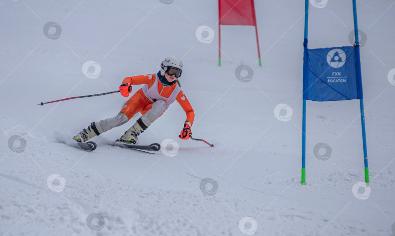 Скачать Россия, Красноярск 25 февраля 2025г. Девочка лыжница, спускается на лыжах по снежному склону. фотосток Ozero