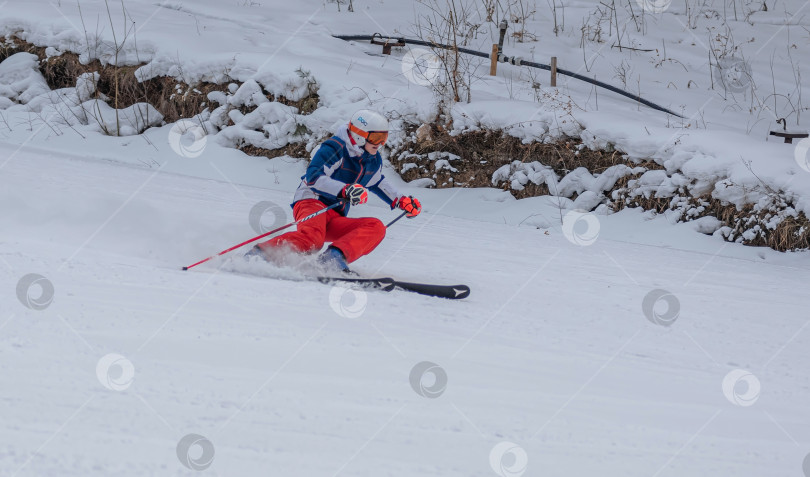 Скачать Россия, Красноярск 25 февраля 2025г. Мальчик лыжник, спускается на лыжах по снежному склону. фотосток Ozero