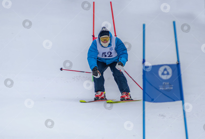 Скачать Россия, Красноярск 25 февраля 2025г. Мужчина лыжник, спускается на лыжах по снежному склону. фотосток Ozero