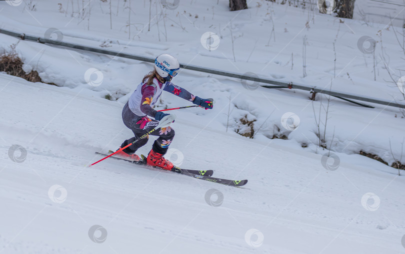Скачать Россия, Красноярск 25 февраля 2025г. Девочка лыжница, спускается на лыжах по снежному склону. фотосток Ozero