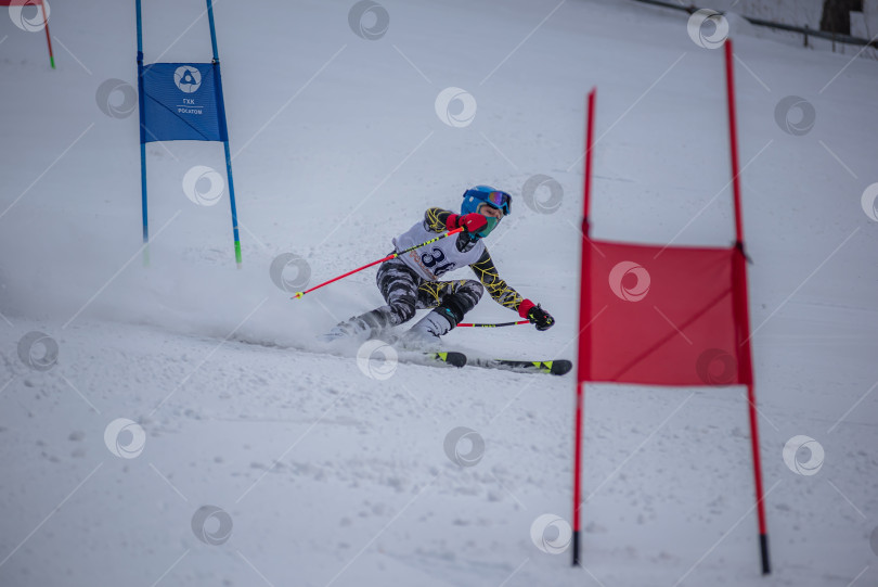 Скачать Россия, Красноярск 25 февраля 2025г. Мальчик лыжник, спускается на лыжах по снежному склону. фотосток Ozero