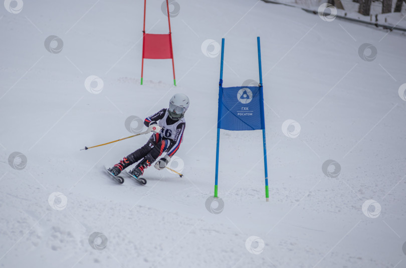Скачать Россия, Красноярск 25 февраля 2025г. Мальчик лыжник, спускается на лыжах по снежному склону. фотосток Ozero