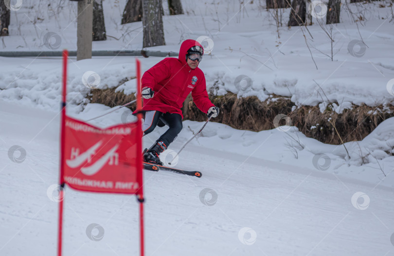 Скачать Россия, Красноярск 25 февраля 2025г. Мужчина лыжник, спускается на лыжах по снежному склону. фотосток Ozero