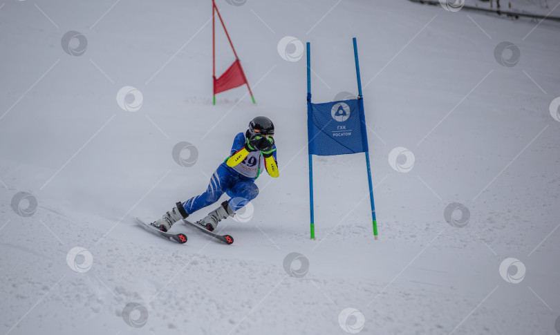 Скачать Россия, Красноярск 25 февраля 2025г. Мальчик лыжник, спускается на лыжах по снежному склону. фотосток Ozero