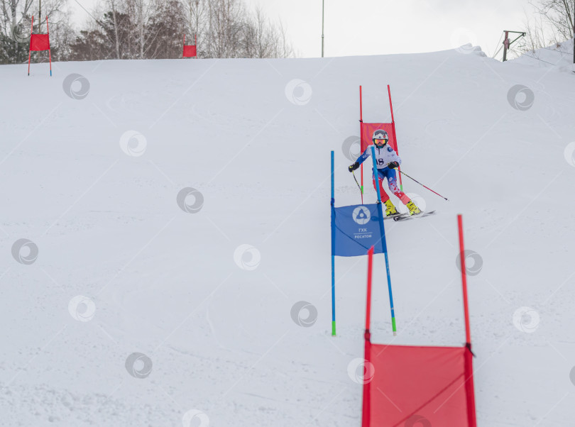 Скачать Россия, Красноярск 25 февраля 2025г. Мальчик лыжник, спускается на лыжах по снежному склону. фотосток Ozero