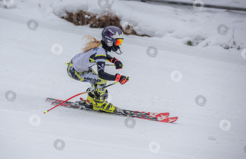 Скачать Россия, Красноярск 25 февраля 2025г. Девочка лыжница, спускается на лыжах по снежному склону. фотосток Ozero