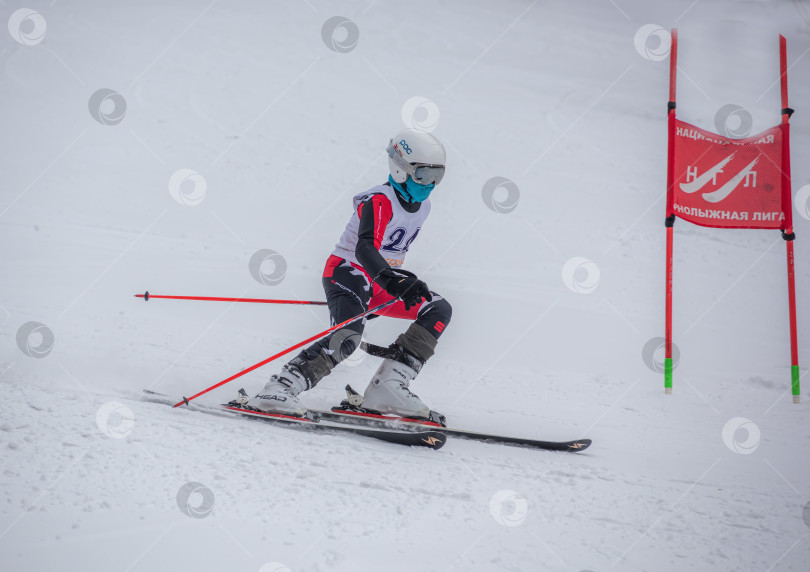 Скачать Россия, Красноярск 25 февраля 2025г. Мальчик лыжник, спускается на лыжах по снежному склону. фотосток Ozero