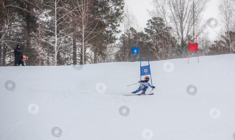 Скачать Россия, Красноярск 25 февраля 2025г. Мальчик лыжник, спускается на лыжах по снежному склону. фотосток Ozero