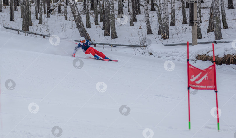 Скачать Россия, Красноярск 25 февраля 2025г. Мальчик лыжник, спускается на лыжах по снежному склону. фотосток Ozero