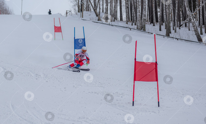 Скачать Россия, Красноярск 25 февраля 2025г. Мальчик лыжник, спускается на лыжах по снежному склону. фотосток Ozero