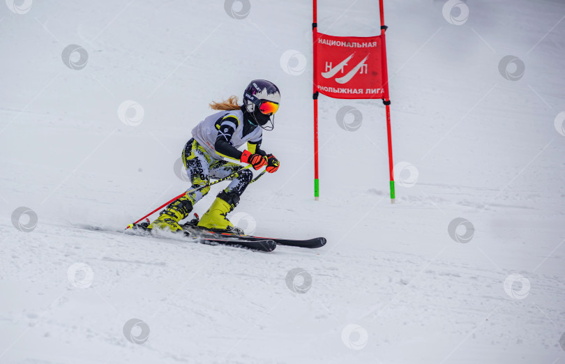 Скачать Россия, Красноярск 25 февраля 2025г. Девочка лыжница, спускается на лыжах по снежному склону. фотосток Ozero