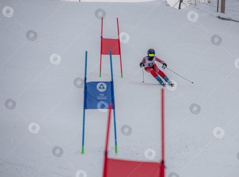 Скачать Россия, Красноярск 25 февраля 2025г. Мальчик лыжник, спускается на лыжах по снежному склону. фотосток Ozero