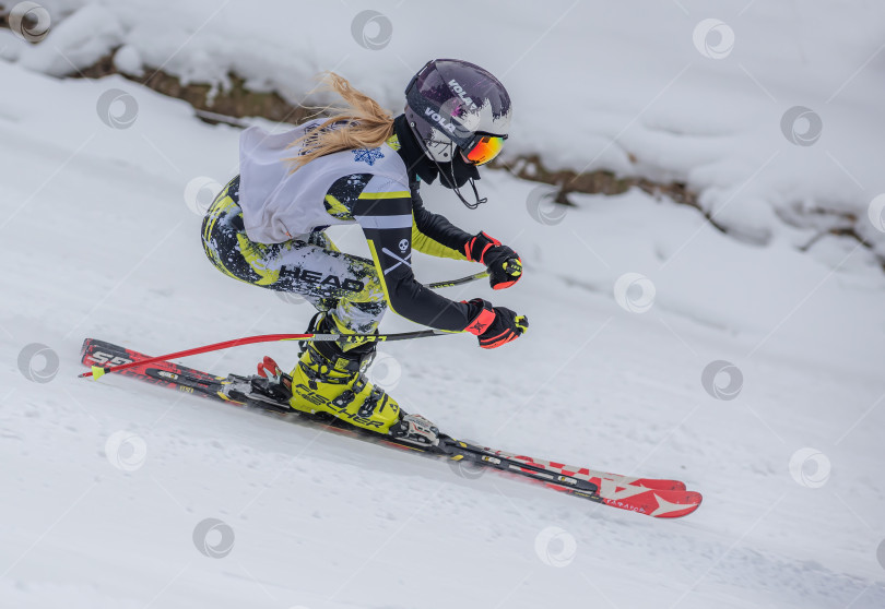 Скачать Россия, Красноярск 25 февраля 2025г. Девочка лыжница, спускается на лыжах по снежному склону. фотосток Ozero