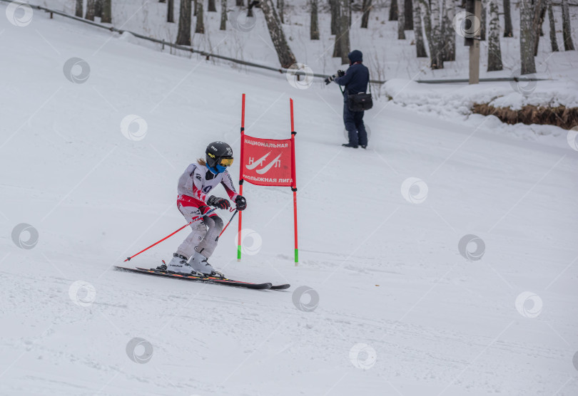 Скачать Россия, Красноярск 25 февраля 2025г. Девочка лыжница, спускается на лыжах по снежному склону. фотосток Ozero