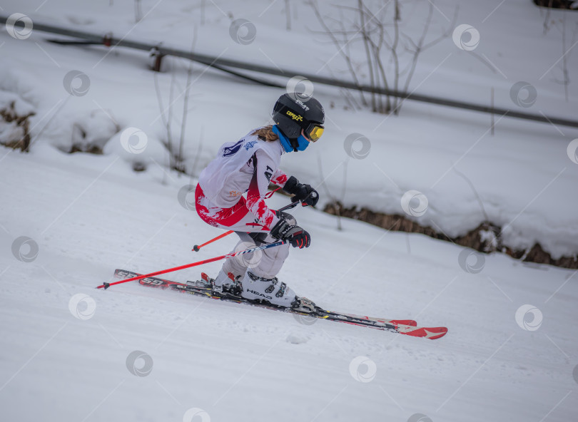 Скачать Россия, Красноярск 25 февраля 2025г. Девочка лыжница, спускается на лыжах по снежному склону. фотосток Ozero