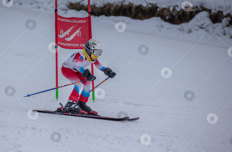Скачать Россия, Красноярск 25 февраля 2025г. Девочка лыжница, спускается на лыжах по снежному склону. фотосток Ozero