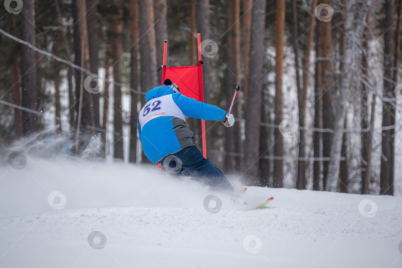 Скачать Россия, Красноярск 25 февраля 2025г. Мужчина лыжник, спускается на лыжах по снежному склону. фотосток Ozero