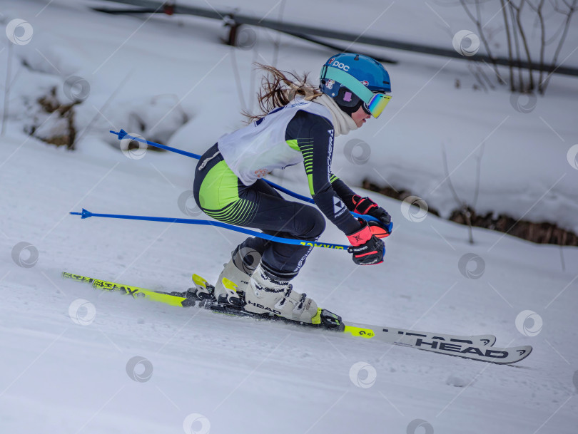 Скачать Россия, Красноярск 25 февраля 2025г. Девочка лыжница, спускается на лыжах по снежному склону. фотосток Ozero