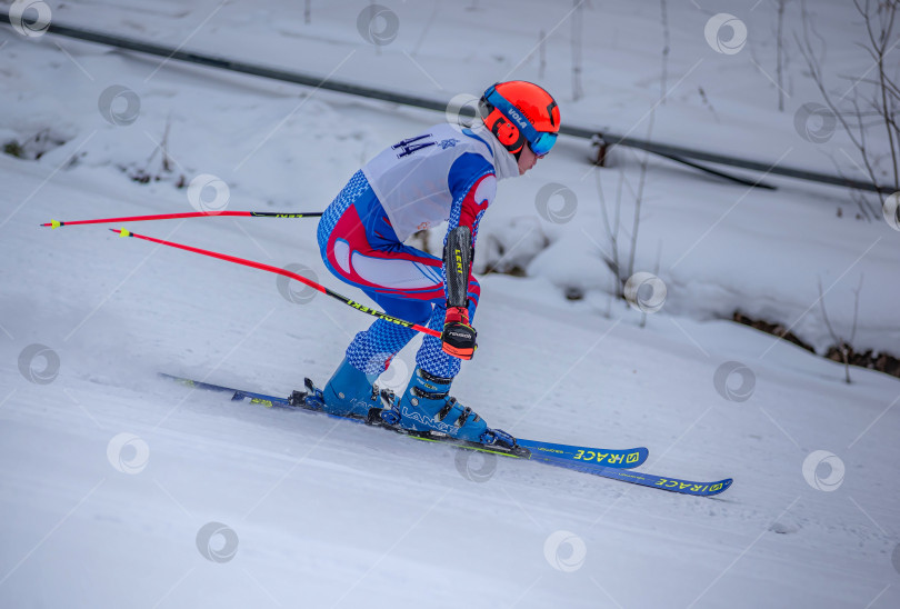 Скачать Россия, Красноярск 25 февраля 2025г. Мальчик лыжник, спускается на лыжах по снежному склону. фотосток Ozero