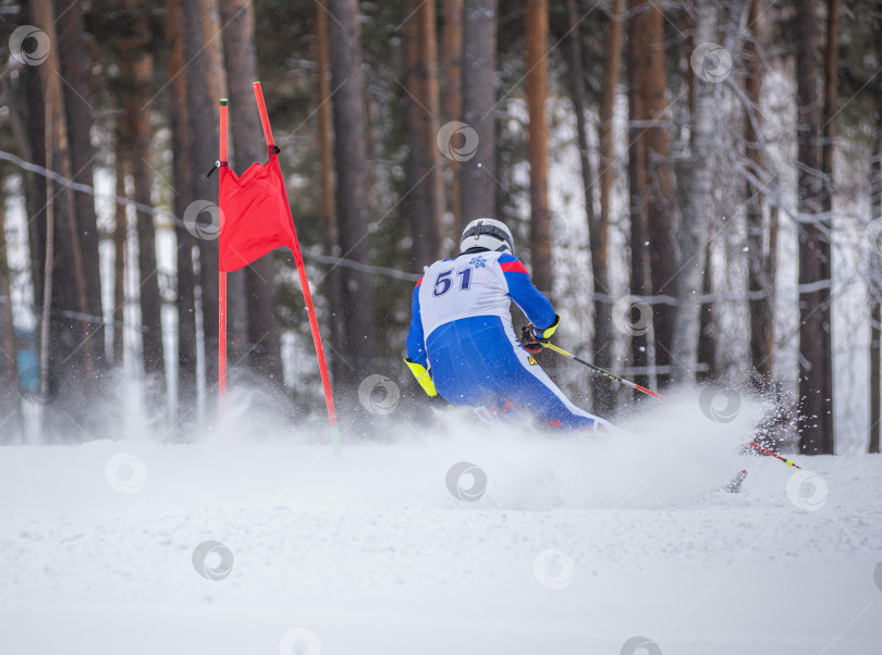 Скачать Россия, Красноярск 25 февраля 2025г. Мужчина лыжник, спускается на лыжах по снежному склону. фотосток Ozero