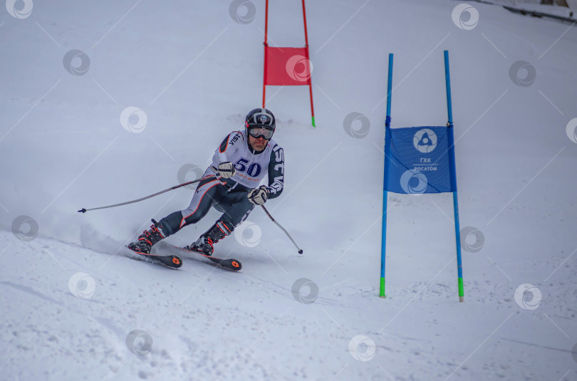 Скачать Россия, Красноярск 25 февраля 2025г. Мужчина лыжник, спускается на лыжах по снежному склону. фотосток Ozero