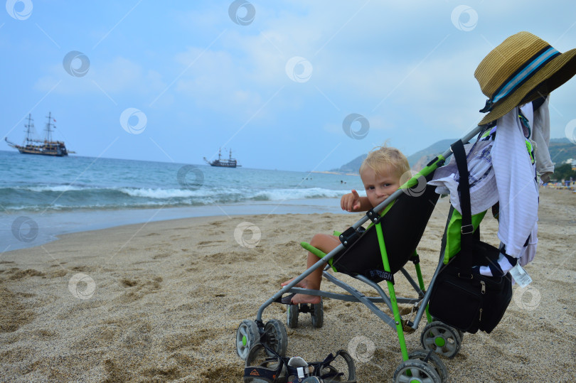 Скачать Ребенок в коляске на берегу моря фотосток Ozero