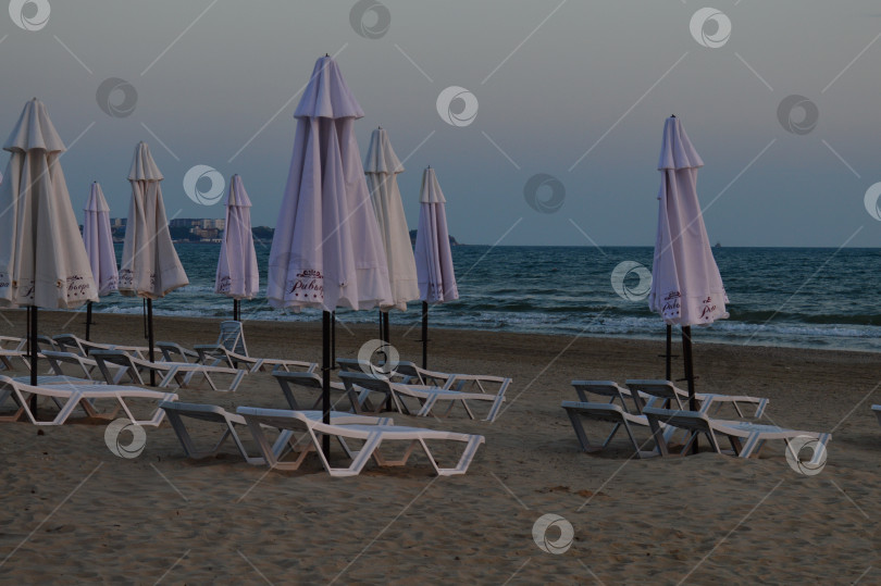 Скачать Шезлонги и зонтики вечером на пляже ,море синее и штормит ,безлюдно фотосток Ozero