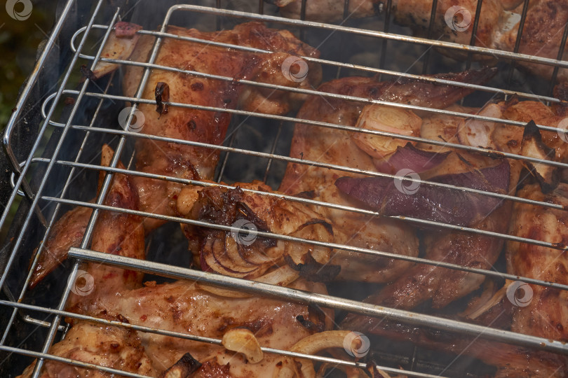Скачать Кусочки курицы с золотистой корочкой обжариваются на гриле над углями. фотосток Ozero