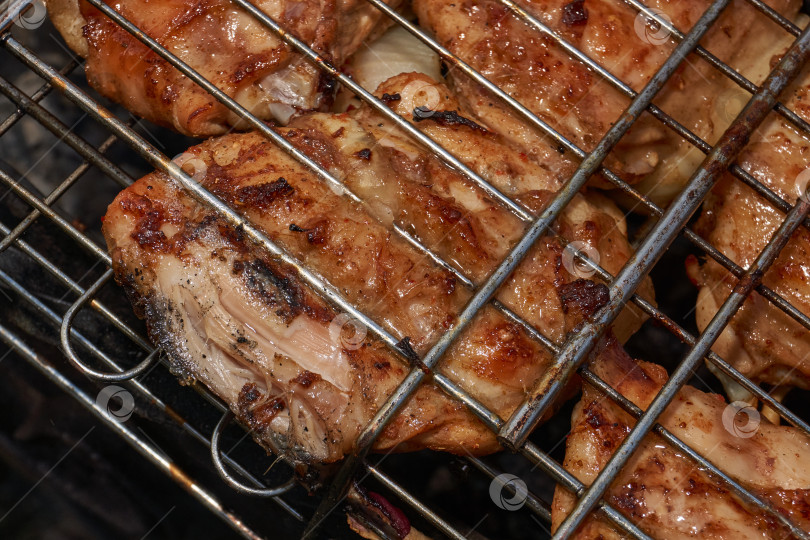Скачать Кусочки курицы с золотистой корочкой обжариваются на гриле над углями. фотосток Ozero