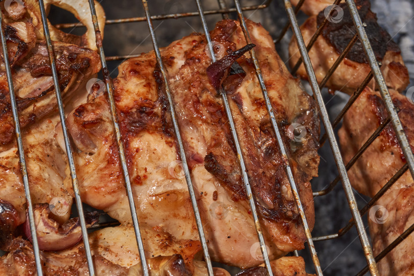 Скачать Кусочки курицы с золотистой корочкой обжариваются на гриле над углями. фотосток Ozero