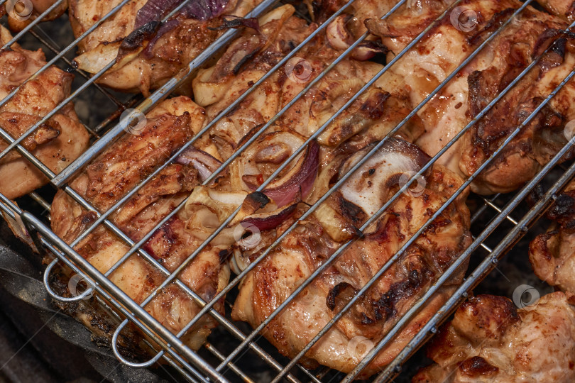 Скачать Кусочки курицы с золотистой корочкой обжариваются на гриле над углями. фотосток Ozero