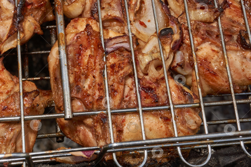 Скачать Кусочки курицы с золотистой корочкой обжариваются на гриле над углями. фотосток Ozero