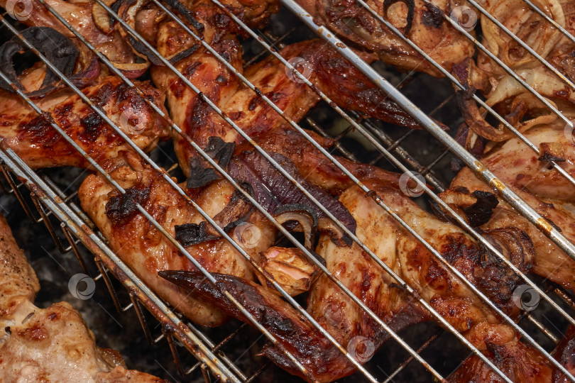 Скачать Кусочки курицы с золотистой корочкой обжариваются на гриле над углями. фотосток Ozero