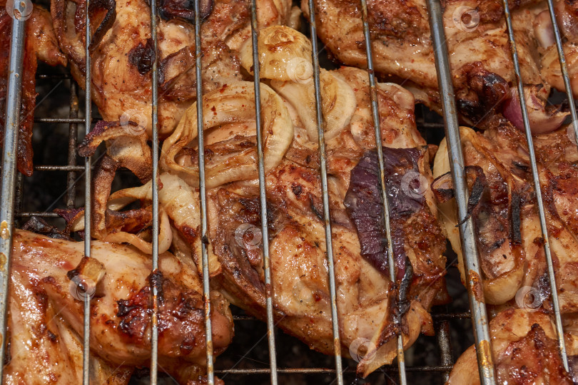 Скачать Кусочки курицы с золотистой корочкой обжариваются на гриле над углями. фотосток Ozero