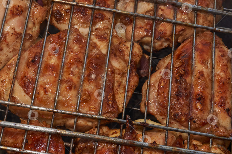 Скачать Кусочки курицы с золотистой корочкой обжариваются на гриле над углями. фотосток Ozero