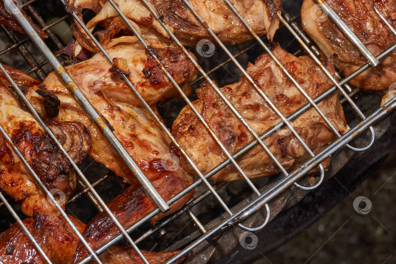 Скачать Кусочки курицы с золотистой корочкой обжариваются на гриле над углями. фотосток Ozero