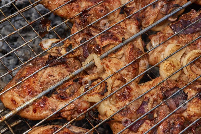 Скачать Кусочки курицы с золотистой корочкой обжариваются на гриле над углями. фотосток Ozero