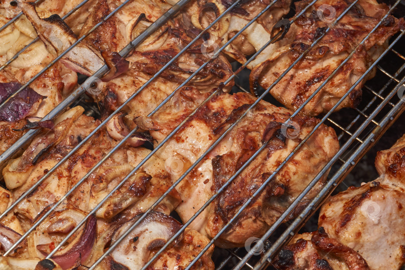 Скачать Кусочки курицы с золотистой корочкой обжариваются на гриле над углями. фотосток Ozero