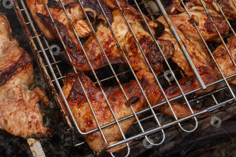 Скачать Кусочки курицы с золотистой корочкой обжариваются на гриле над углями. фотосток Ozero