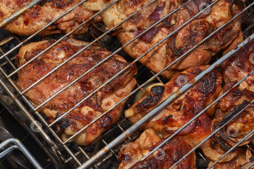 Скачать Кусочки курицы с золотистой корочкой обжариваются на гриле над углями. фотосток Ozero