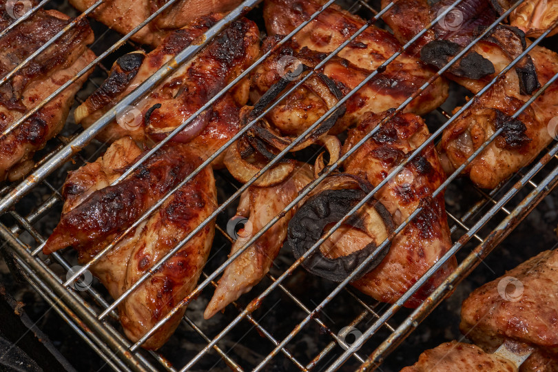 Скачать Кусочки курицы с золотистой корочкой обжариваются на гриле над углями. фотосток Ozero