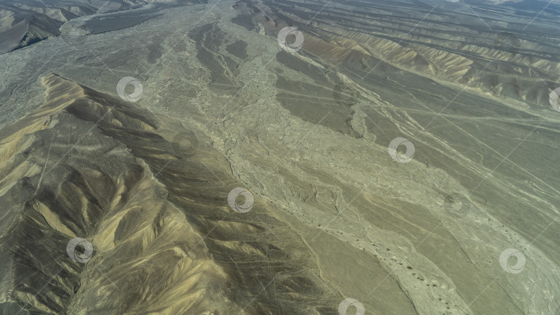 Скачать Пролетая над плато Наска. Русла высохших рек причудливо извиваются по песку пустыни фотосток Ozero