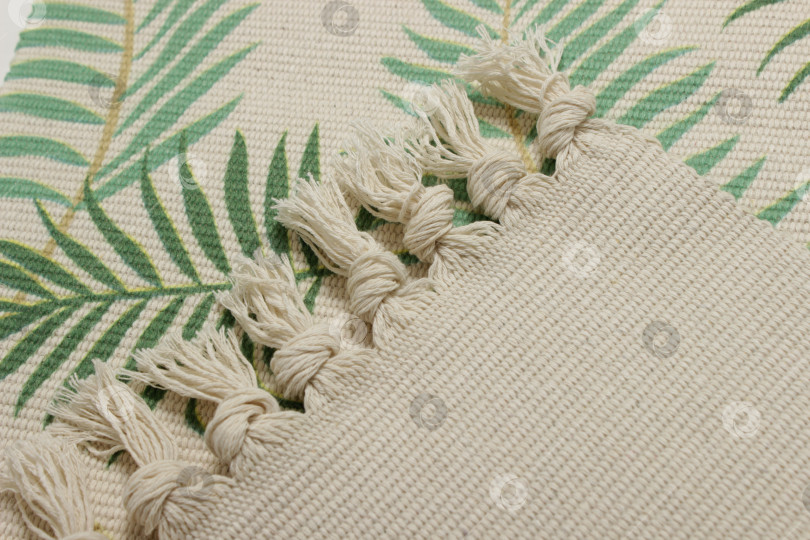 Скачать Крупный план зеленого хлопчатобумажного коврика с бахромой по краю. фотосток Ozero