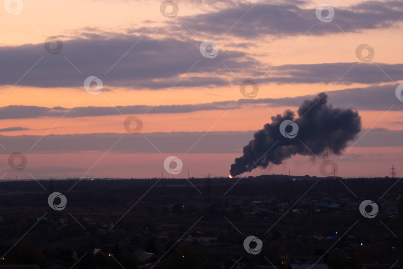 Скачать Промышленный дым поднимается над городом на закате фотосток Ozero