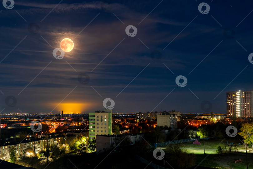 Скачать Полная луна над освещенным ночным городским пейзажем фотосток Ozero